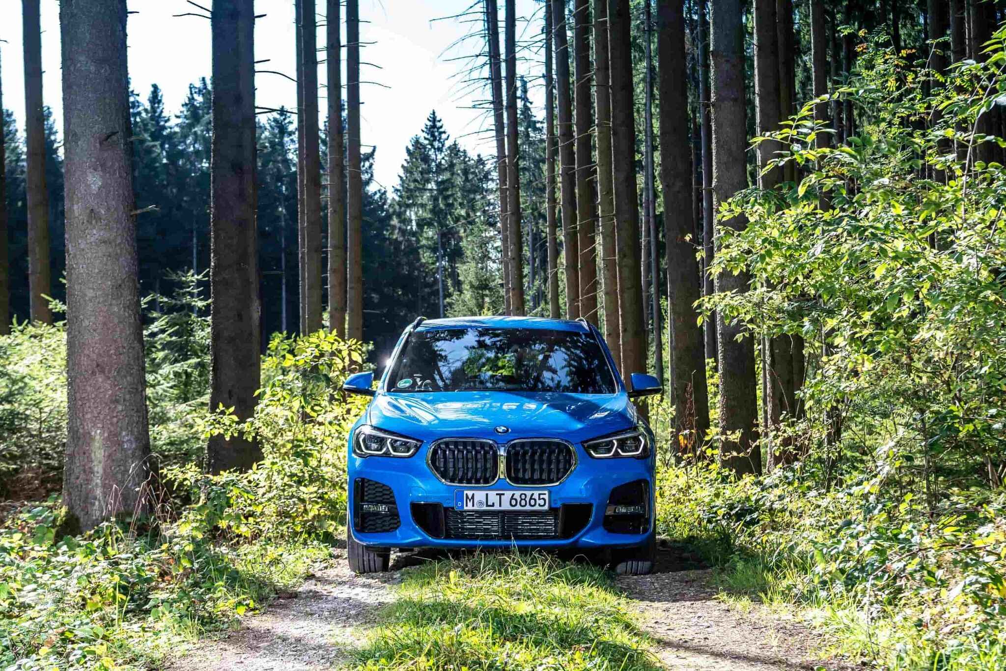 Blue BMW X1 in a Forest
