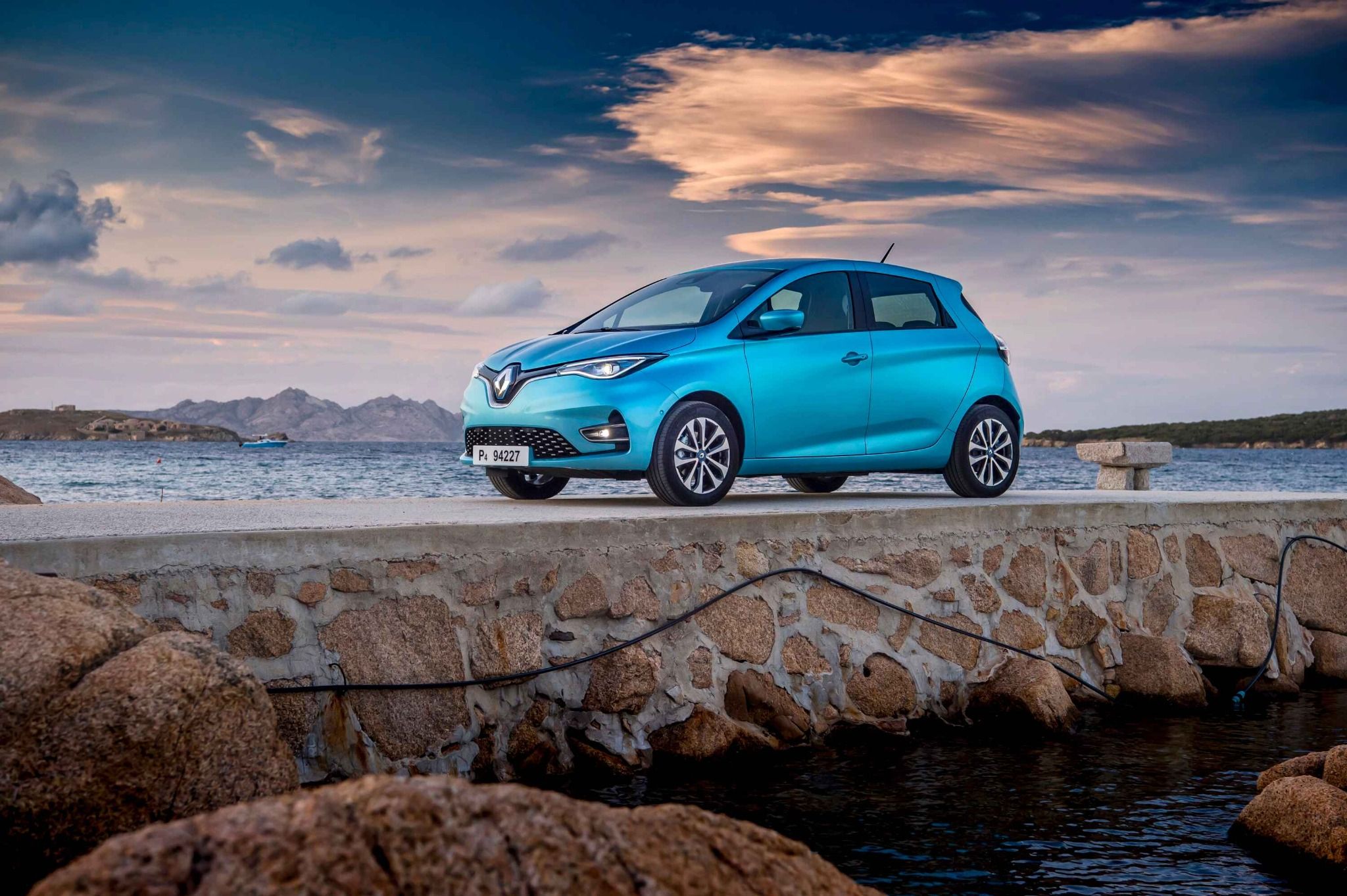 Blue Renault Parked On Stone Road Infront Of Water
