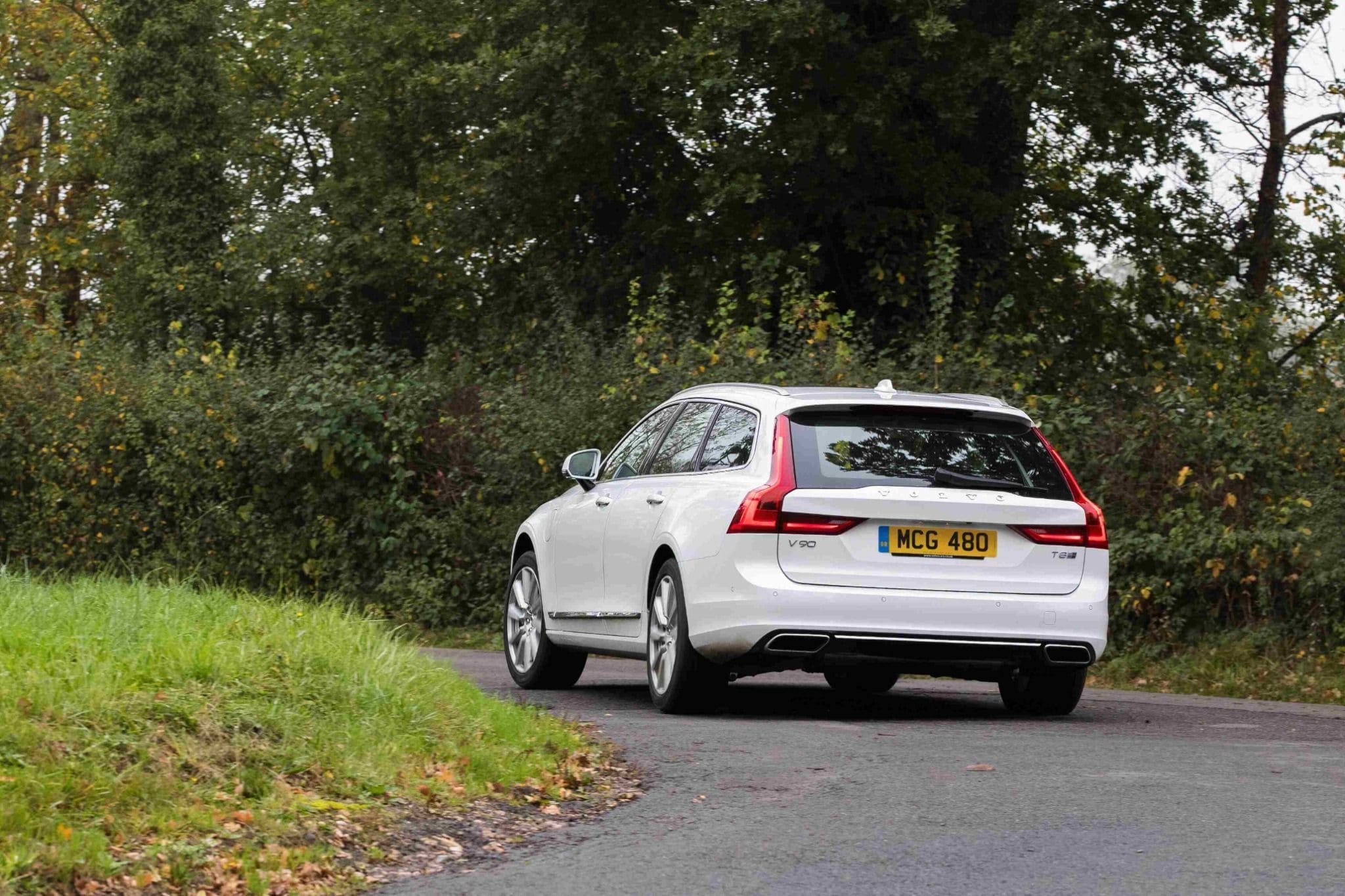 rear side of white volvo v90 driving away