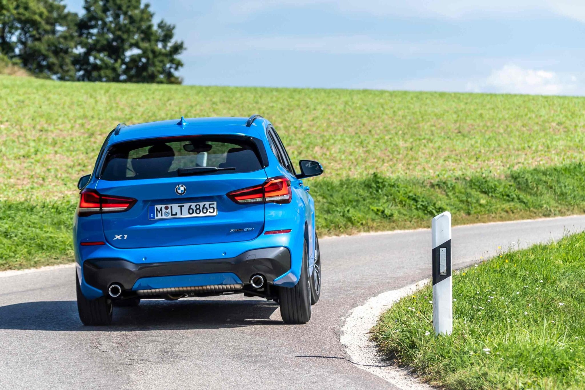 Rear of BMW X1 Driving on a Road