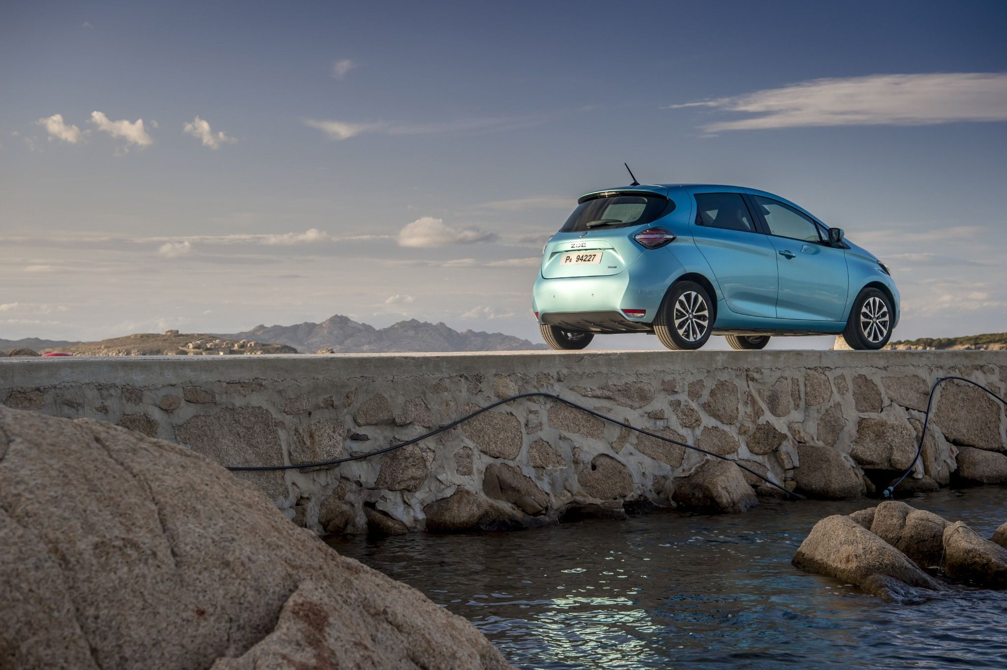 blue renault zoe side view on a dirt road