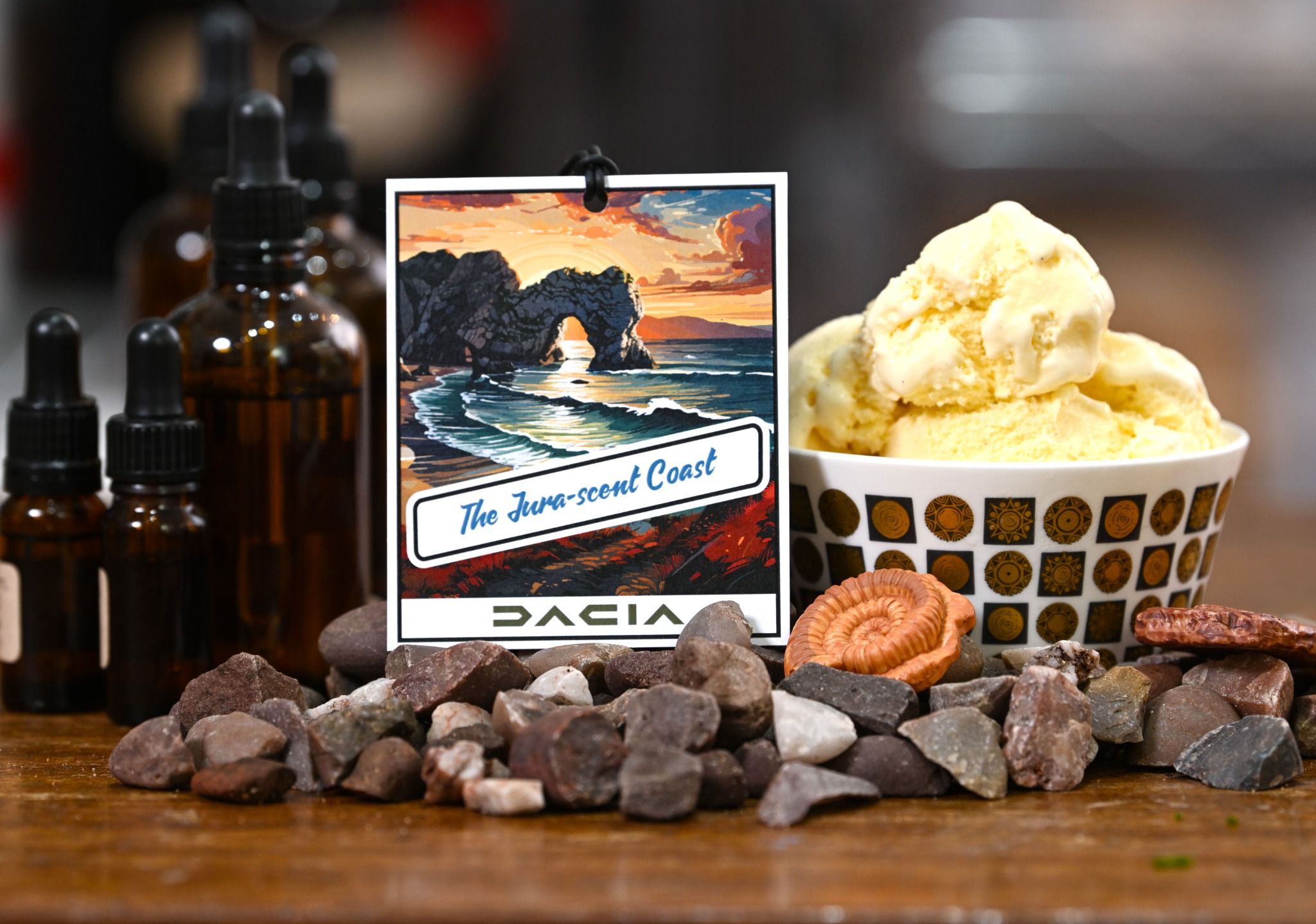 Dacia sir freshener: The Jura-scent Coast displayed with a bowl of ice-cream, pepples, fossils and bottles of essential oil