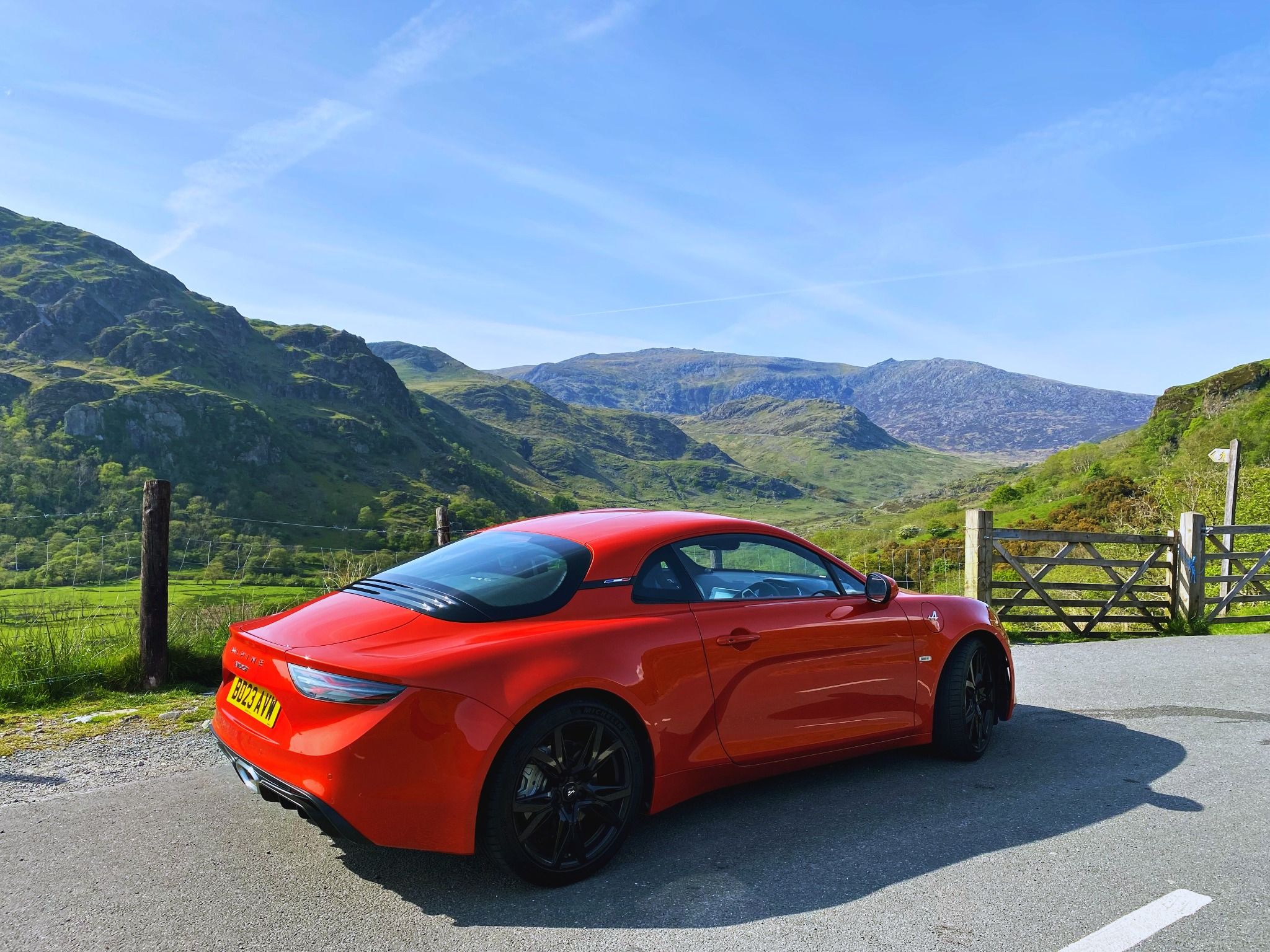 Red Alpine A110 with a backdrop of hills