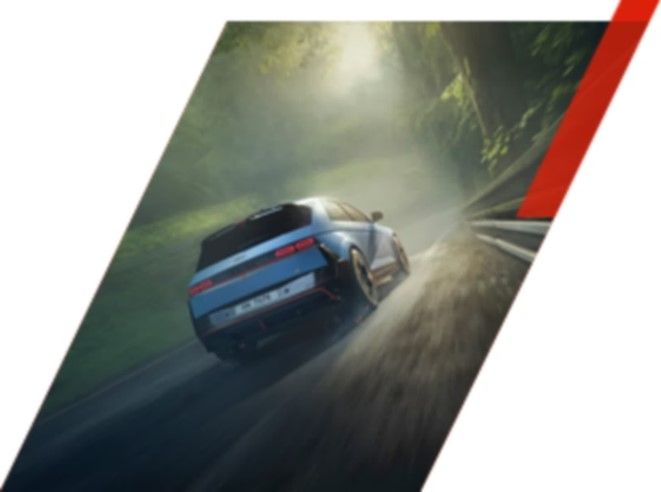 Rear view of a Blue IONIQ 5 N driving down a tree-lined road