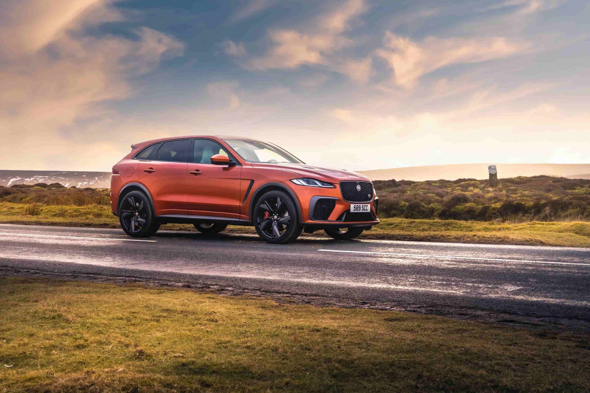 Orange Jaguar F-Pace driving down country road