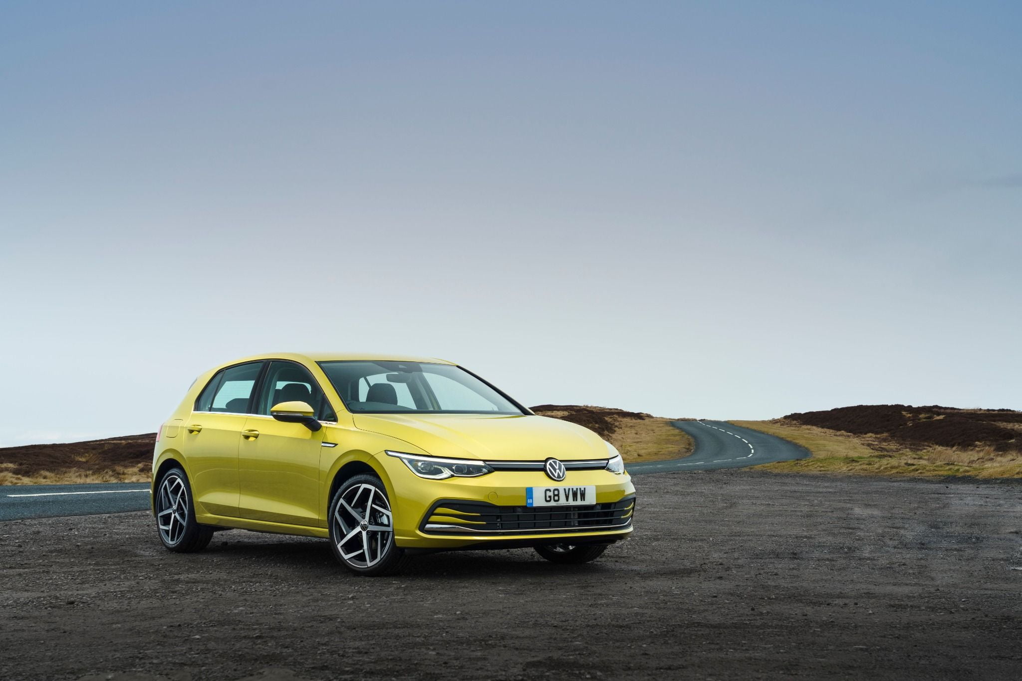 Yellow Volkswagen Golf parked on a hill