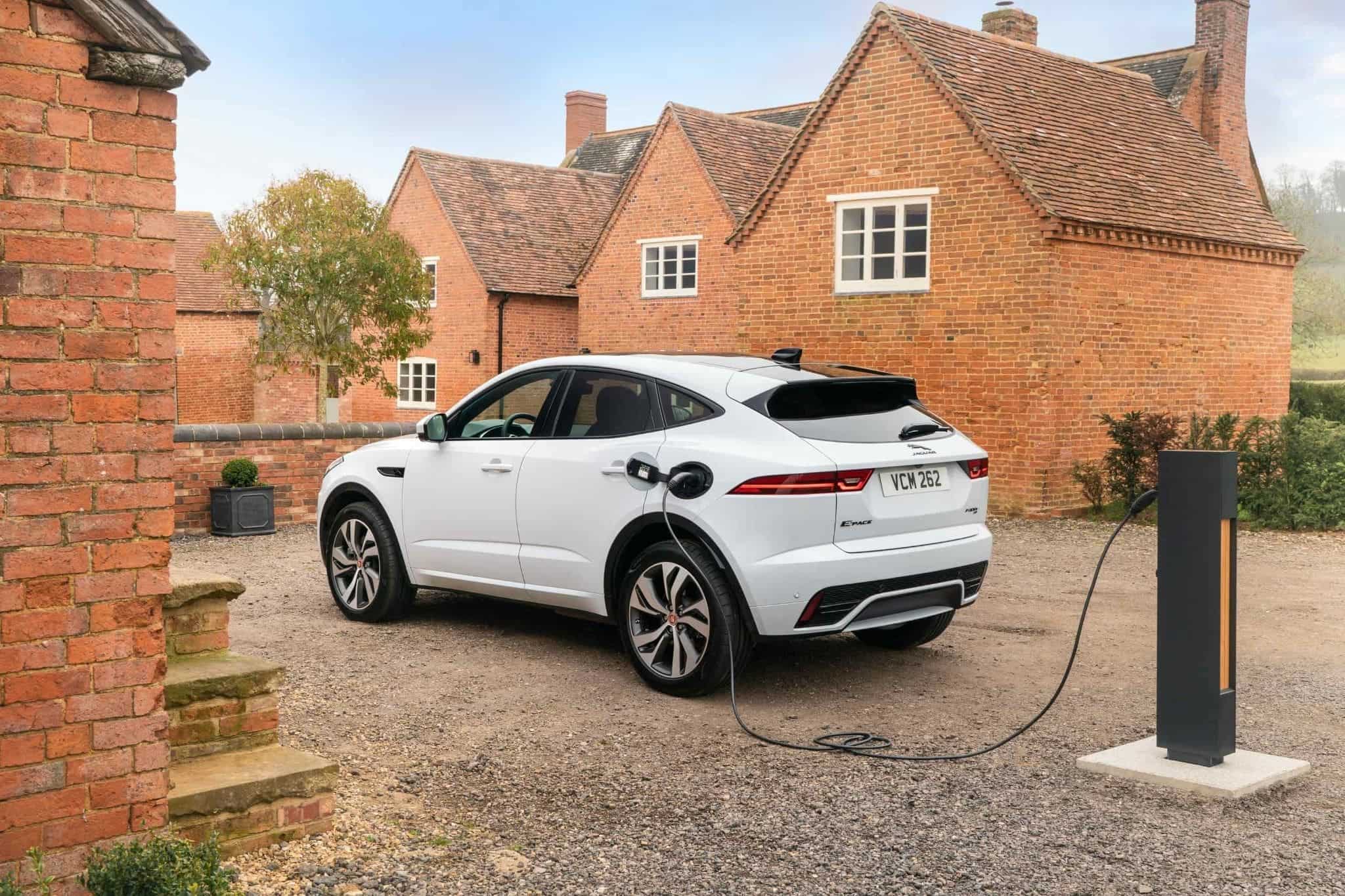 white jaguar e pace charging outside a residential home